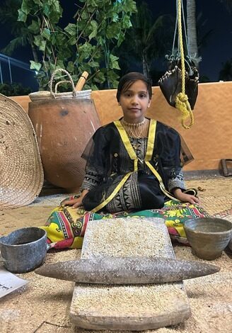 زوار من نجران يشيدون بركن الطوال وطفلات يتعلمن عادات قديمة في ركن محافظة الطوال بالمهرجان